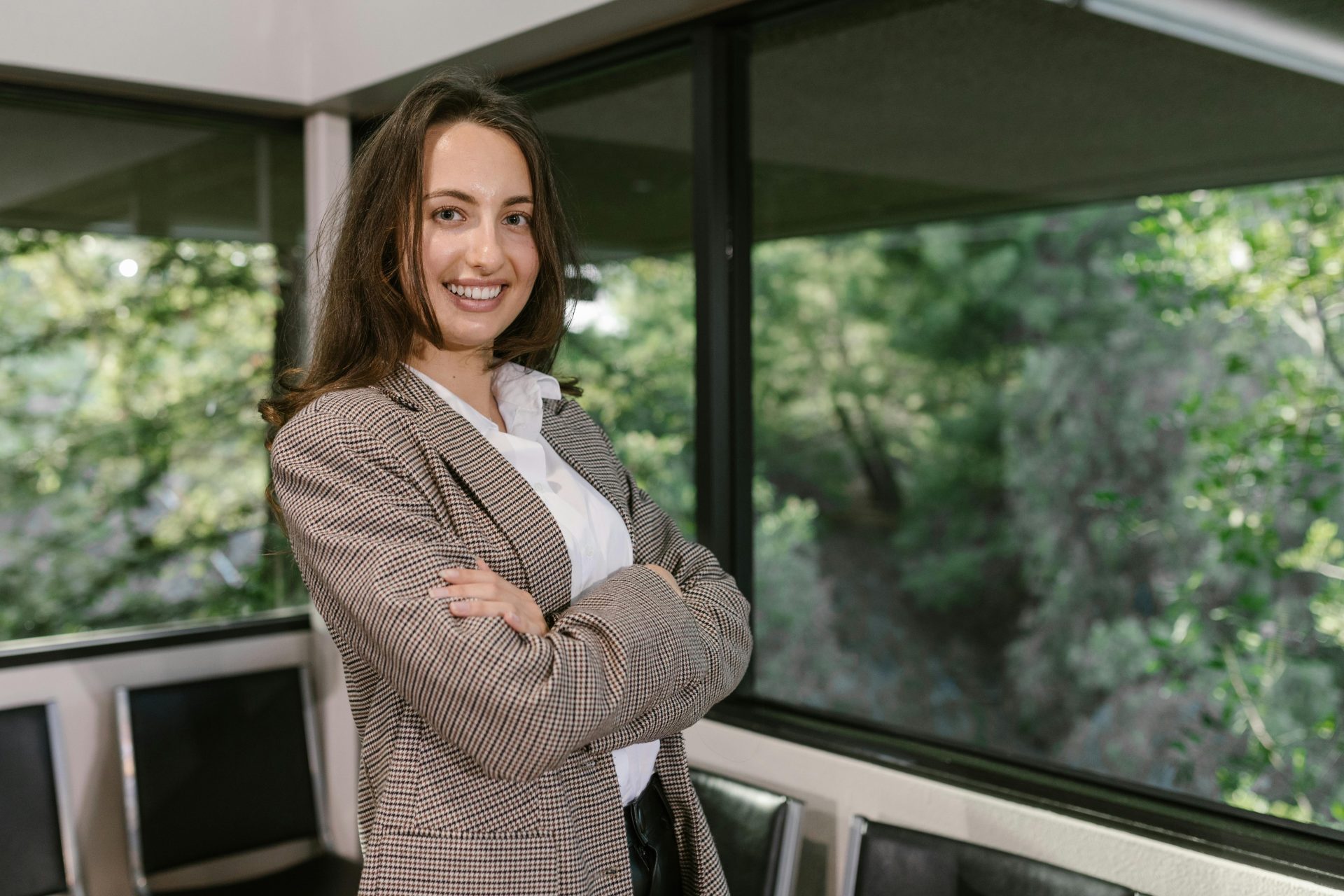 Portrait of a smiling businesswoman in an office with large windows.