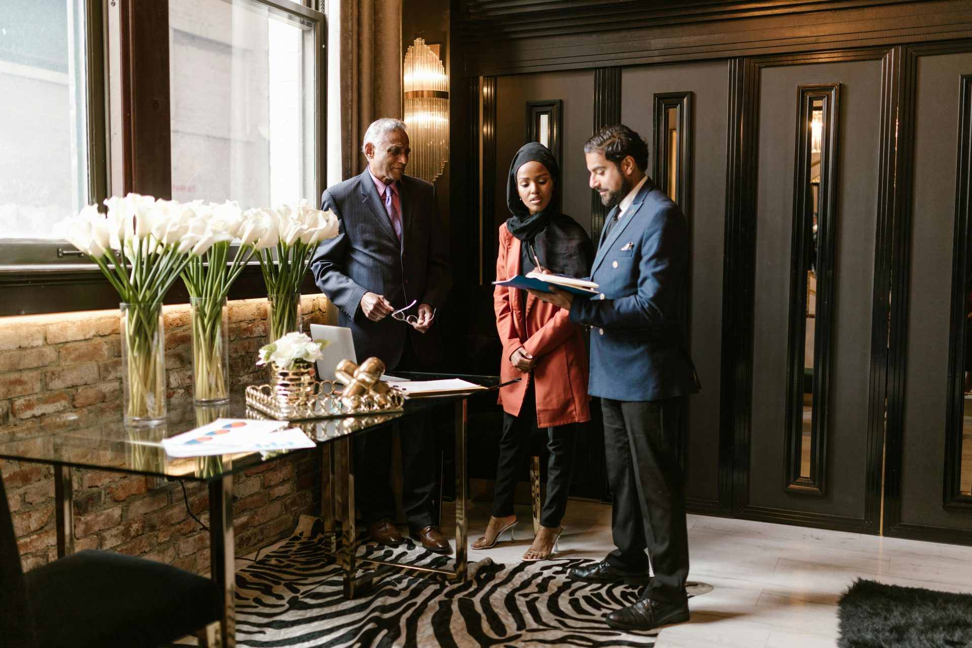 Professionals discussing in an elegant hotel lobby with luxurious interior design and decor.